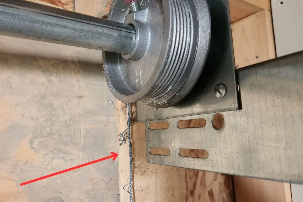 Frayed garage door cable next to drum identified during safety check