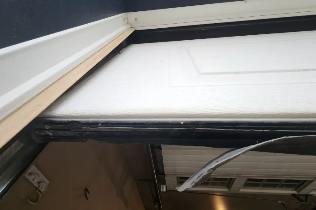 Misaligned garage door panel and damaged seal spotted during inspection