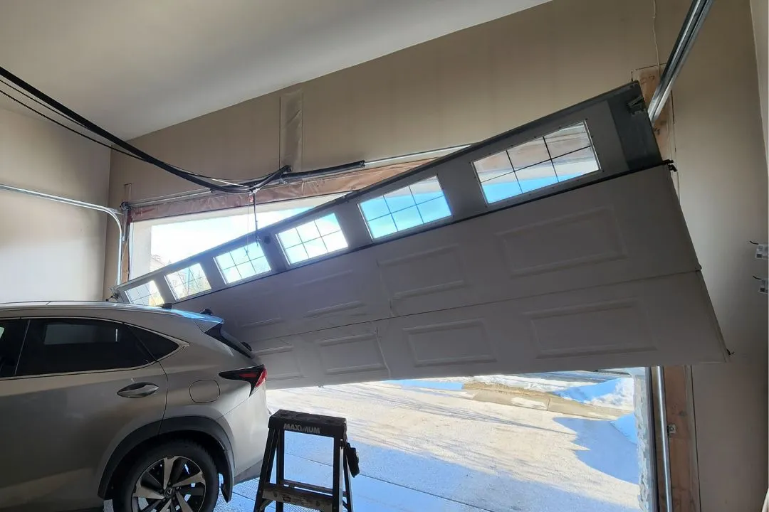 Garage door off-track in St. Albert garage, hanging above parked car