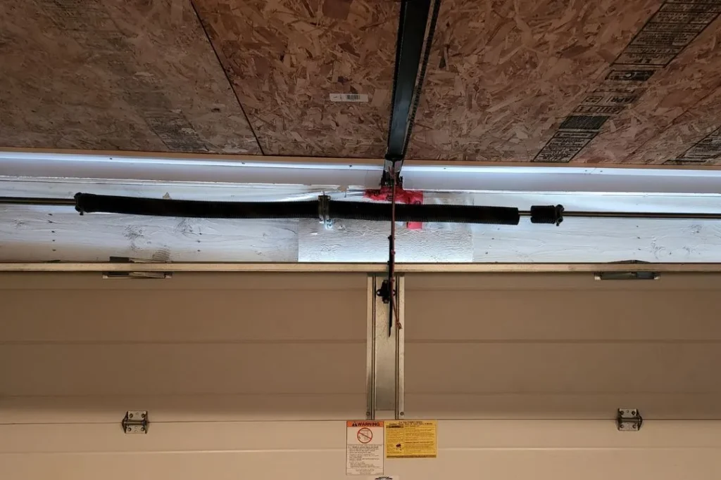 Split torsion spring on a garage door in Leduc, preventing the door from lifting properly.